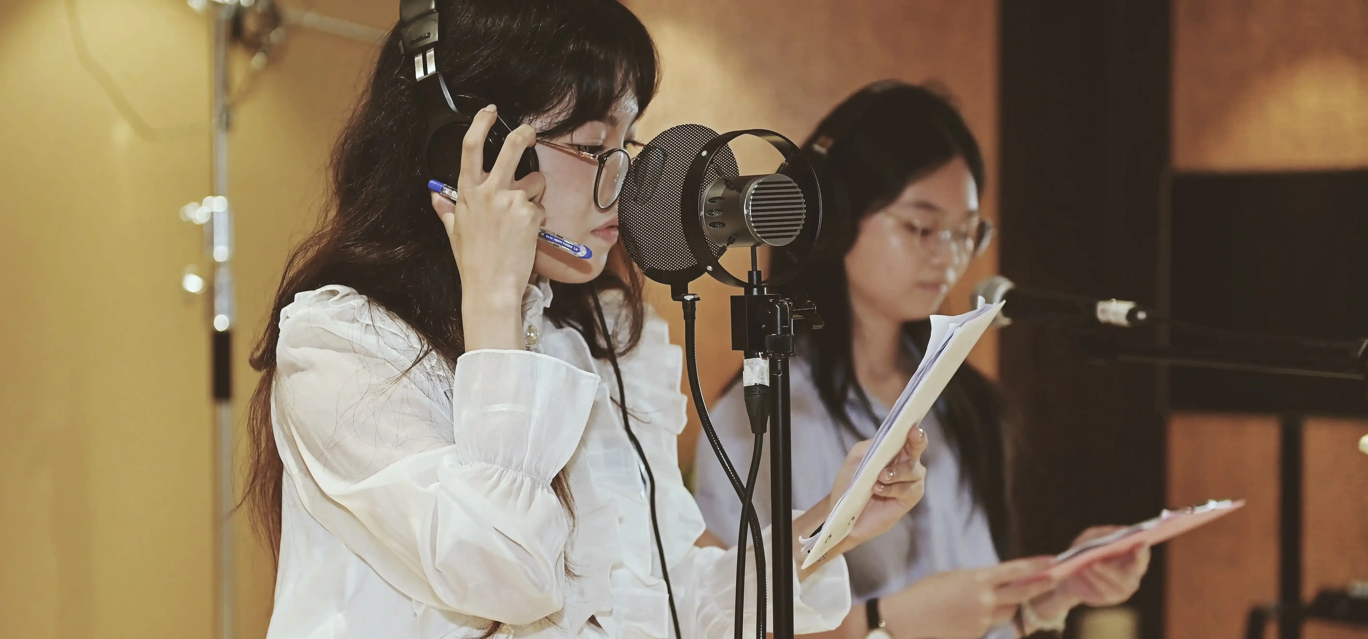 Group of smiling students collaborating on a broadcast project in a recording studio.